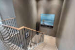 Modern staircase with sleek metal balusters and light wood handrail adds a touch of elegance to this home.