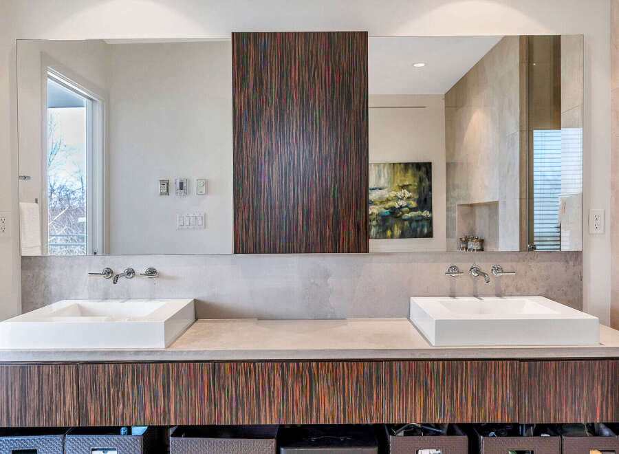 This luxurious bathroom boasts a double vanity with sleek, square sinks and modern chrome faucets.