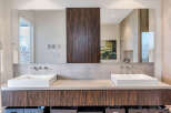 This luxurious bathroom boasts a double vanity with sleek, square sinks and modern chrome faucets.