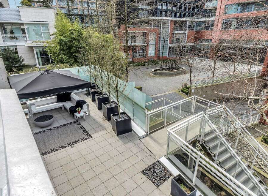 This luxurious condo boasts a private patio with a fire pit, modern furniture, and a retractable awning, perfect for outdoor entertaining.