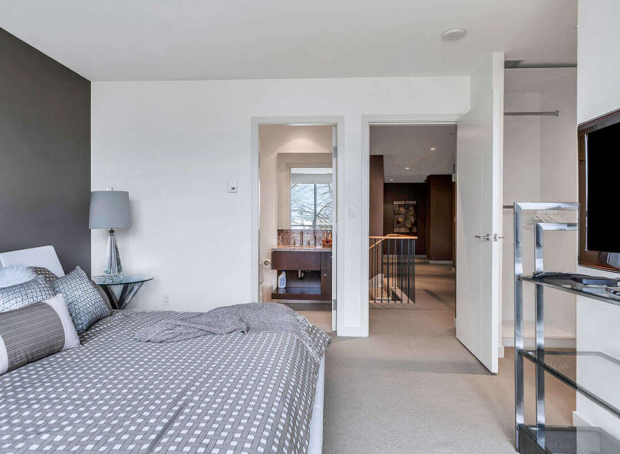 This modern bedroom boasts a stylish gray and white color scheme, complemented by a geometric patterned duvet.