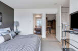 This modern bedroom boasts a stylish gray and white color scheme, complemented by a geometric patterned duvet.