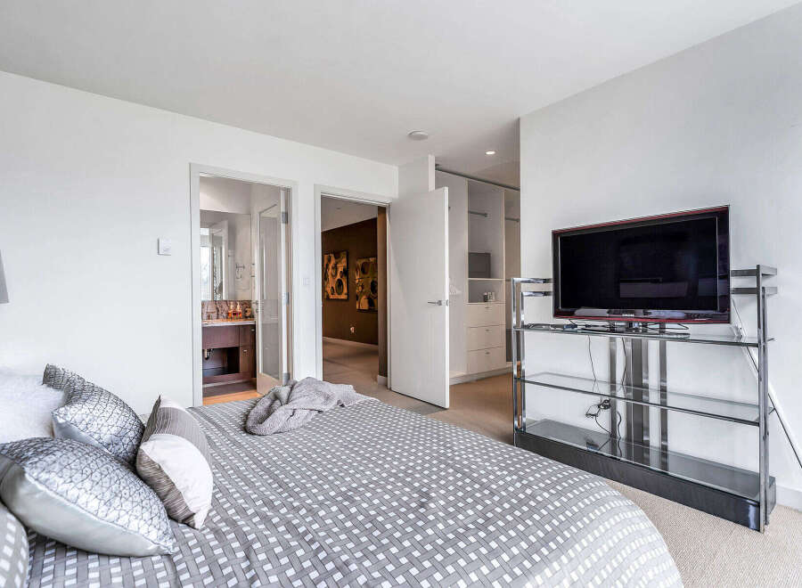 This luxurious bedroom boasts a spacious layout, featuring an ensuite bathroom and a walk-in closet, providing ample storage space.