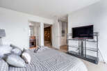 This luxurious bedroom boasts a spacious layout, featuring an ensuite bathroom and a walk-in closet, providing ample storage space.