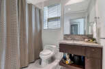 This stunning bathroom boasts a modern design with a spacious vanity featuring granite countertops and ample storage.