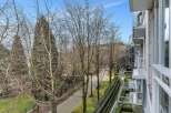 This stunning property boasts a private balcony overlooking a serene, tree-lined walkway, perfect for enjoying morning coffee or evening relaxation.
