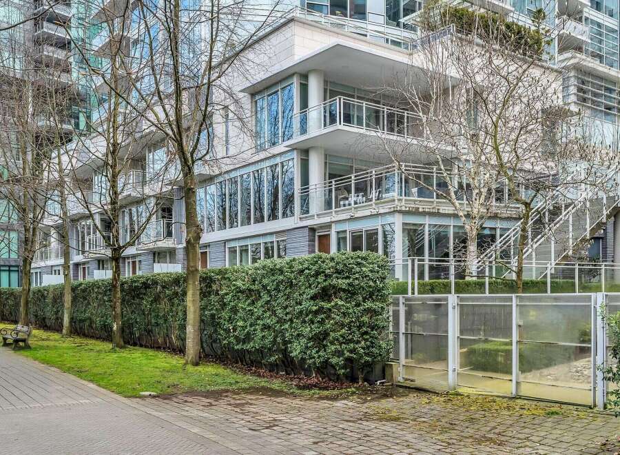 This modern building features a sleek design with floor-to-ceiling windows, private balconies, and a well-maintained landscaped area.