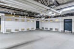 This spacious parking garage boasts two large, white roll-up doors, each featuring multiple windows for ample natural light and ventilation.