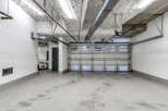 This spacious garage boasts high ceilings, ample space for parking, and modern finishes.