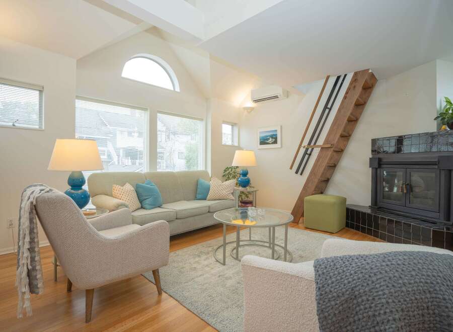Cozy living room with vaulted ceilings, hardwood floors, and a modern fireplace.
