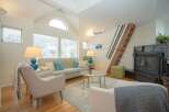 Cozy living room with vaulted ceilings, hardwood floors, and a modern fireplace.