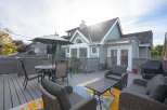 This charming home boasts a spacious deck perfect for outdoor entertaining, complete with comfortable wicker furniture and a dining set.