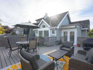 This charming home boasts a spacious deck perfect for outdoor entertaining, complete with comfortable wicker furniture and a dining set.