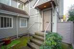 This charming house boasts a welcoming front entrance with a covered porch and steps leading to a light taupe door.