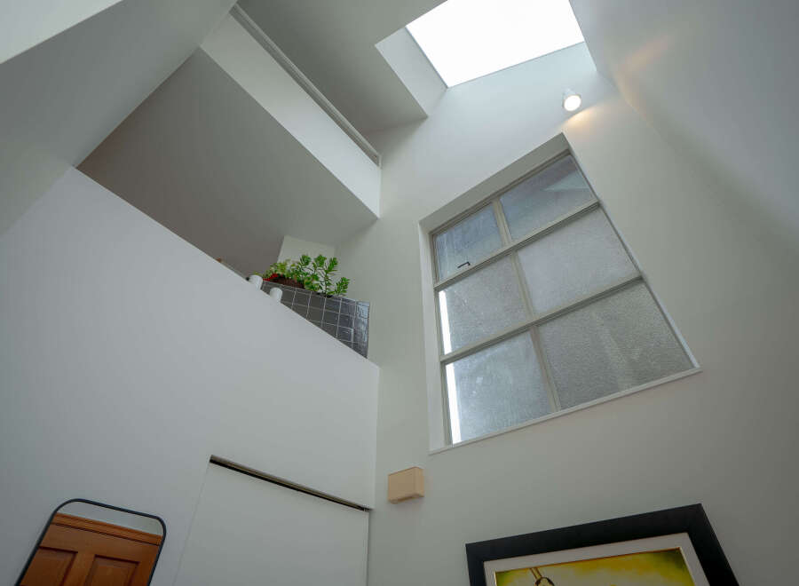 This modern home boasts a unique architectural design with a skylight and large windows that fill the space with natural light.