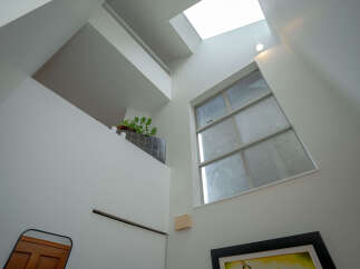 This modern home boasts a unique architectural design with a skylight and large windows that fill the space with natural light.