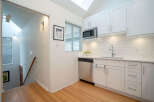 This bright and airy kitchen boasts modern white shaker cabinets, stainless steel appliances, and sleek countertops.
