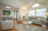 Bright and airy living room with vaulted ceilings and large windows, offering plenty of natural light.