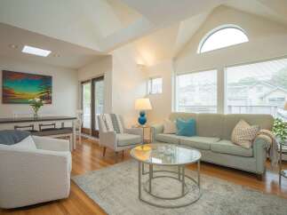 Bright and airy living room with vaulted ceilings and large windows, offering plenty of natural light.