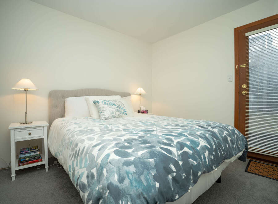 Cozy bedroom with a comfortable queen-size bed featuring a teal and white duvet cover.