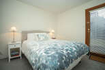 Cozy bedroom with a comfortable queen-size bed featuring a teal and white duvet cover.