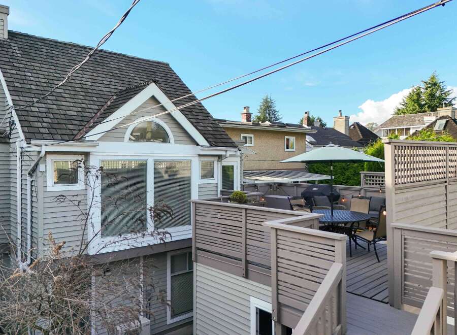This charming home boasts a spacious deck perfect for outdoor entertaining, complete with a dining area, grill, and pergola.