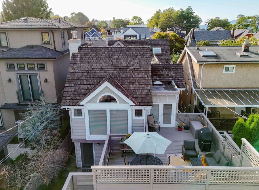This charming home boasts a spacious deck perfect for outdoor entertaining, complete with a pergola, comfortable seating, and a built-in grill.