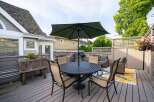 This charming backyard boasts a spacious deck, perfect for outdoor dining and relaxation.