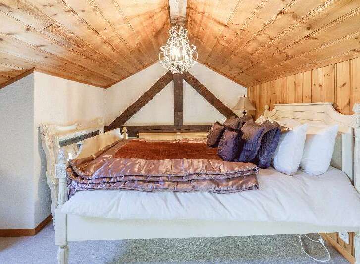 Experience rustic charm in this cozy bedroom, featuring a stunning wooden ceiling and exposed beams.