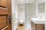 Step into a beautifully designed bathroom featuring a modern shower enclosure and a sleek, contemporary sink.