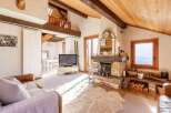 Experience the charm of this cozy chalet, featuring a stunning fireplace and exposed wooden beams.