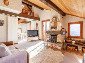 Experience the charm of this cozy chalet, featuring a stunning fireplace and exposed wooden beams.