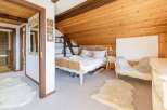 Discover the charm of this cozy bedroom, featuring a unique wooden ceiling and a touch of rustic elegance.