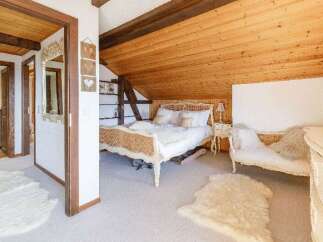 Discover the charm of this cozy bedroom, featuring a unique wooden ceiling and a touch of rustic elegance.