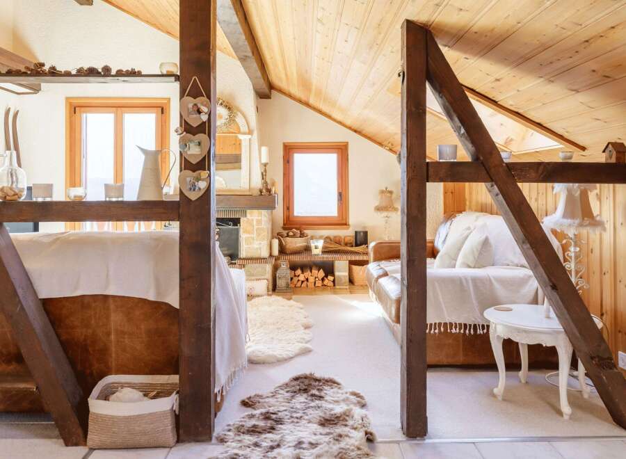 Discover the charm of this cozy attic retreat, featuring exposed wooden beams and a warm, inviting atmosphere.