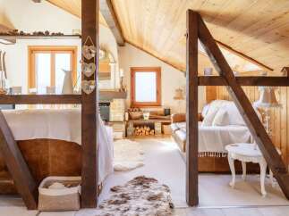 Discover the charm of this cozy attic retreat, featuring exposed wooden beams and a warm, inviting atmosphere.