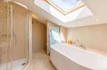 This luxurious bathroom features a modern design with a sleek, white bathtub and a separate shower.