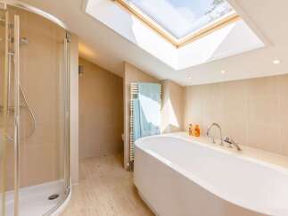 This luxurious bathroom features a modern design with a sleek, white bathtub and a separate shower.
