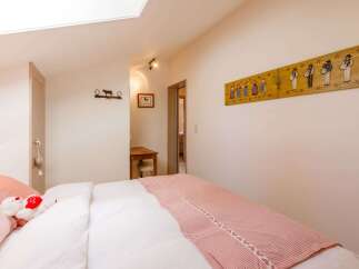 This charming bedroom features a cozy bed with a stylish red and white patterned blanket.