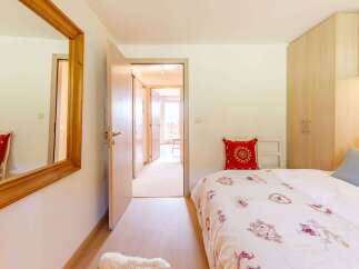 This cozy bedroom features a comfortable bed with a decorative comforter and pillows.