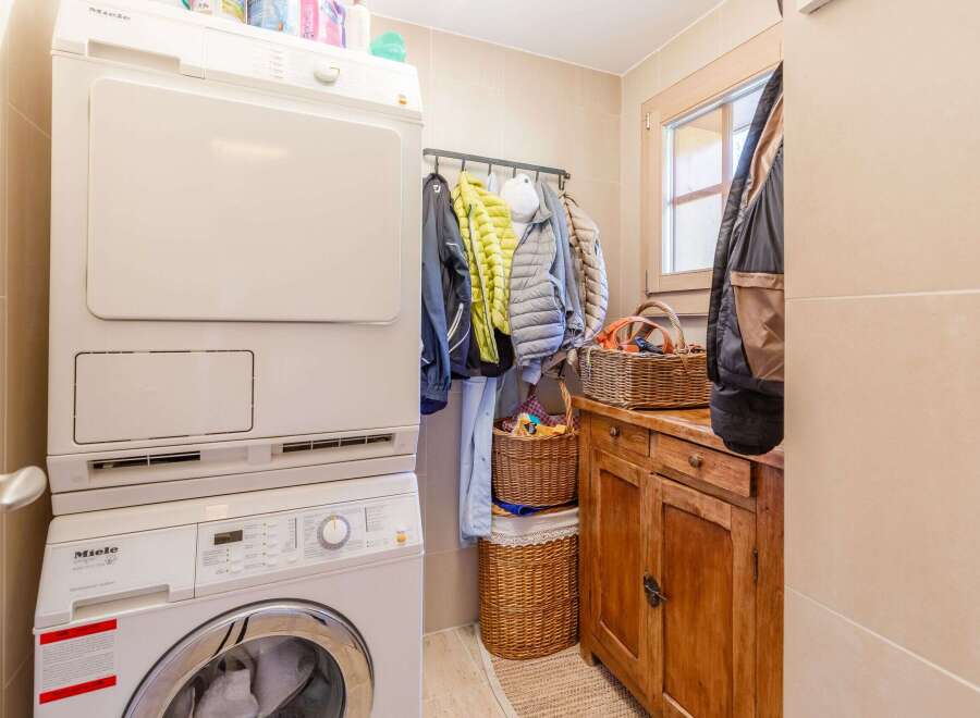 This cozy laundry room features a modern Miele washer and dryer set, perfect for efficient laundry days.