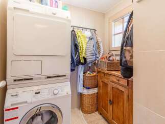 This cozy laundry room features a modern Miele washer and dryer set, perfect for efficient laundry days.