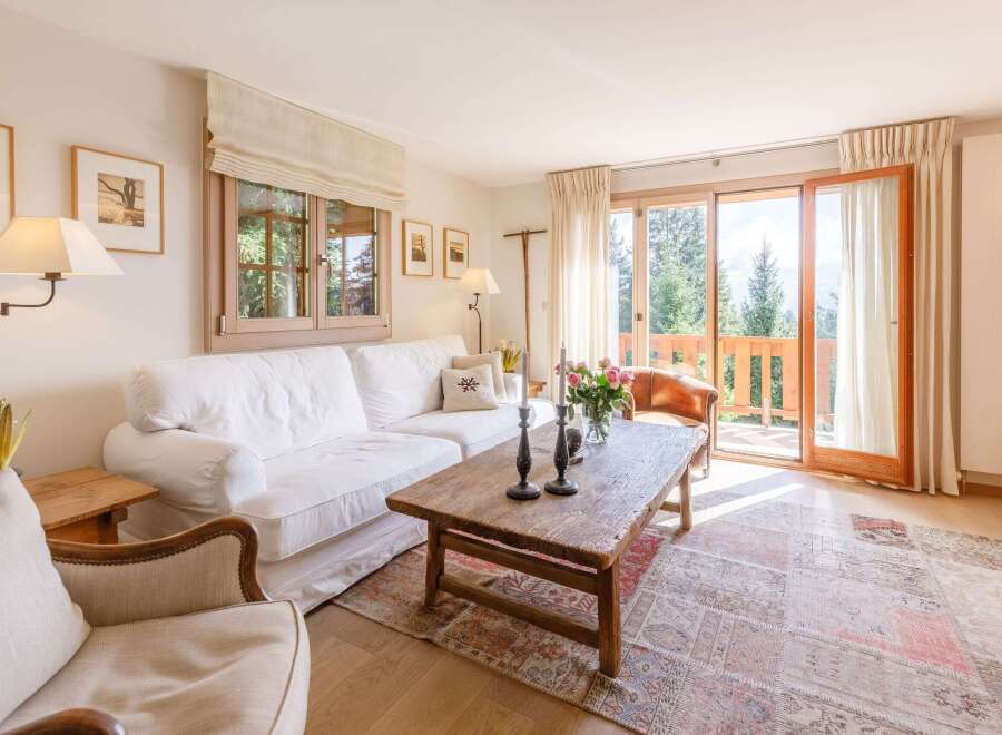 Experience the charm of this cozy living room, featuring a comfortable white sofa and a rustic wooden coffee table.