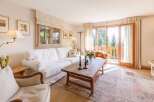 Experience the charm of this cozy living room, featuring a comfortable white sofa and a rustic wooden coffee table.