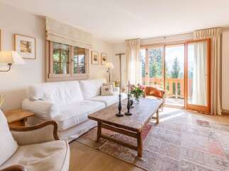 Experience the charm of this cozy living room, featuring a comfortable white sofa and a rustic wooden coffee table.