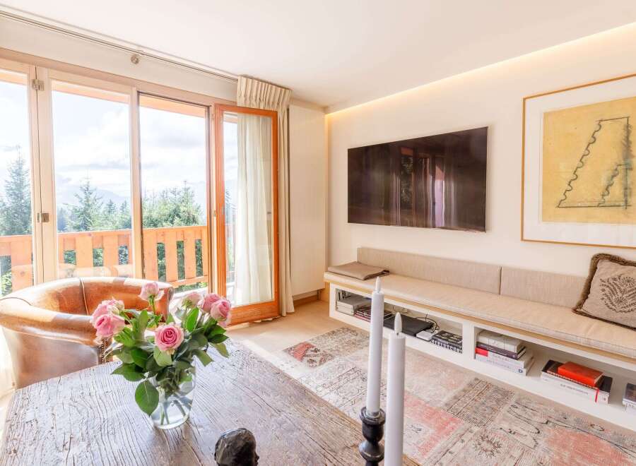 This stunning living space boasts a seamless blend of indoor and outdoor living with expansive windows offering breathtaking views.