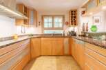 This stunning kitchen boasts custom wooden cabinetry and granite countertops, creating a warm and inviting atmosphere.