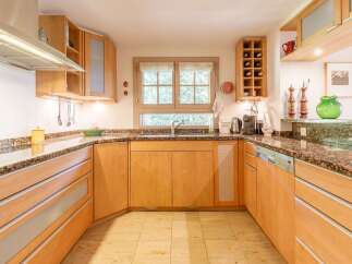 This stunning kitchen boasts custom wooden cabinetry and granite countertops, creating a warm and inviting atmosphere.