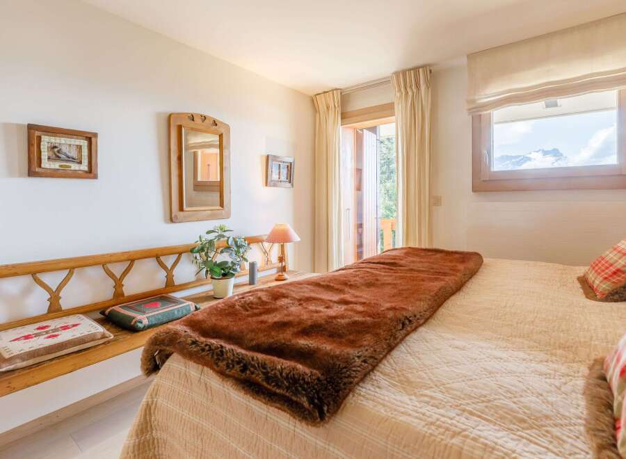 Cozy bedroom with a rustic wooden bench and a plush brown throw blanket.