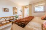 Cozy bedroom with a rustic wooden bench and a plush brown throw blanket.